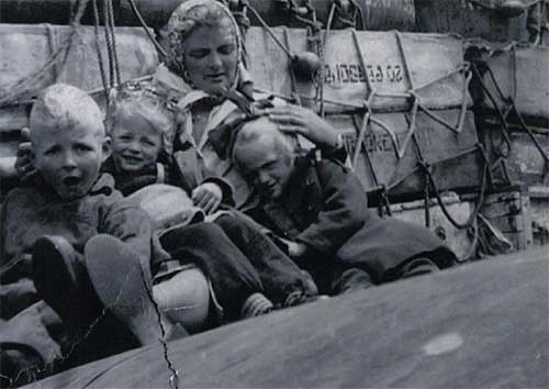 Young lady with three kids sitting on a boat.