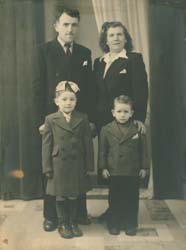 Full-length family portrait of mother, father and two small children.
