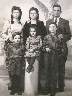 Family portrait with three children in front and three adults in back.