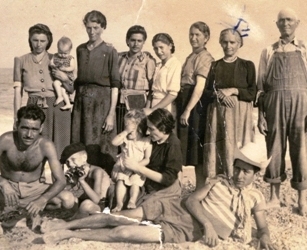 Yellowed, family photo with several members either seated or standing.