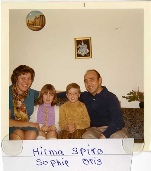 Man and woman sitting on a couch with two children between them.