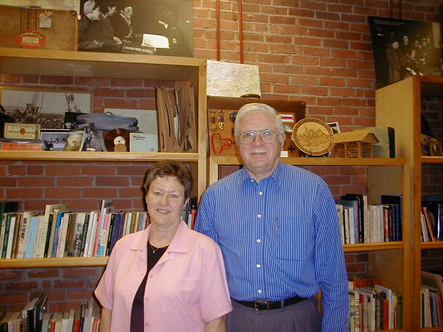 Man and woman standing in front of book shelf.