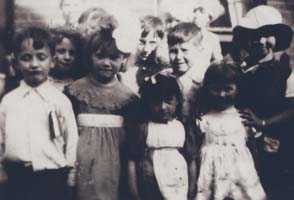 Old photo showing large group of smiling children.