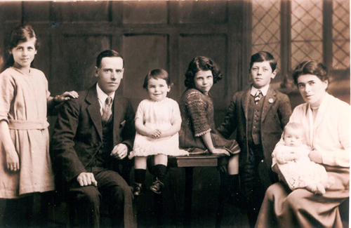 Family portrait of a man and a woman and five children of various ages.