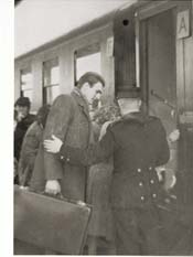 John boarding train with suitcase in hand, conductor checking his ticket.