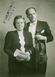 Janis holding a violin and a bow, and Felicita standing beside her.