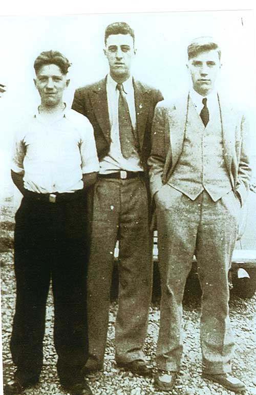 Three men stand together and pose for the camera.