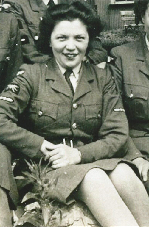 A young woman in a military uniform is seated between two people.