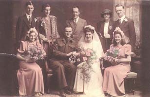 Bride and groom, surrounded by bridal party and family members.