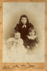 Faded portrait of baby boy in white and two little girls in dark dresses.