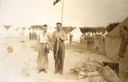 Faded photo showing two men holding up fish.