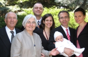 Coloured photo of family with small baby in christening gown.