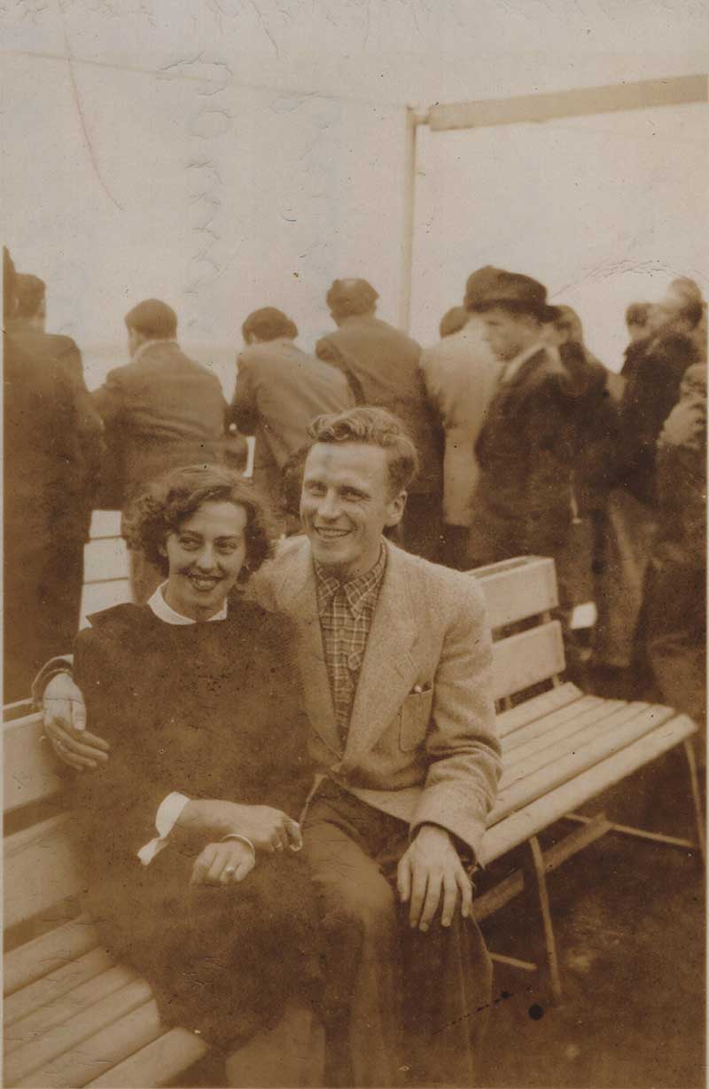 Grainy image of a young couple sitting on deck chairs of a ship.