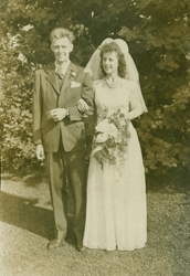 Young John with his wife, on the wedding day, standing in front of trees.
