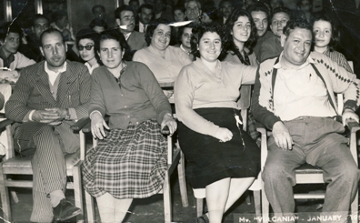 Two men and two women seated in front row of chairs.