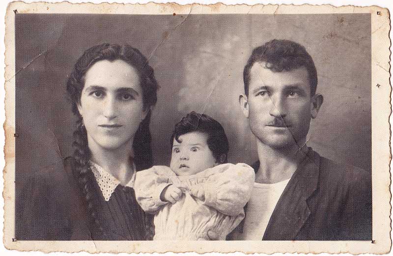 Old black and white photo of young couple with their baby.