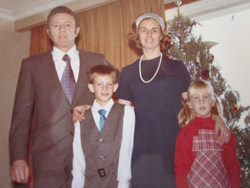 A well-dressed man and woman pose for the camera with two children.
