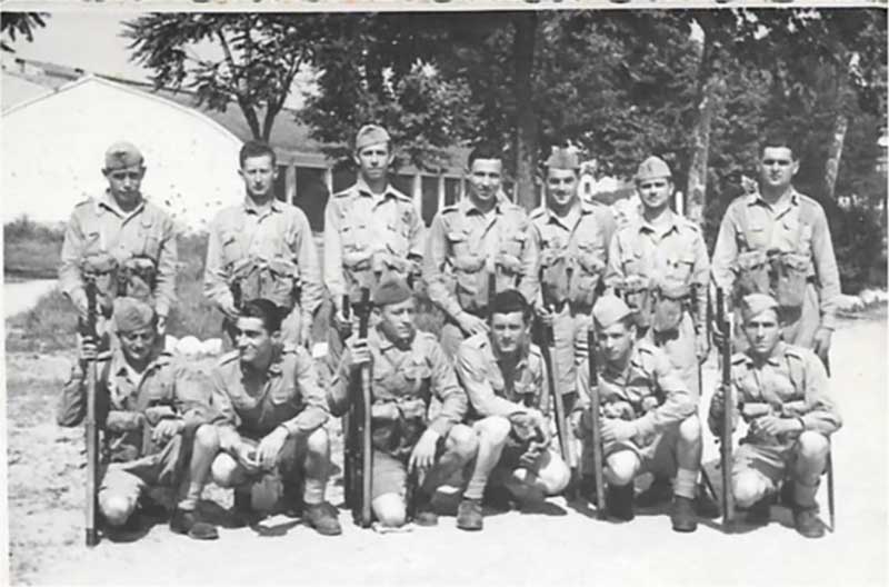 Group of men dressed in military uniform, having their photo taken.