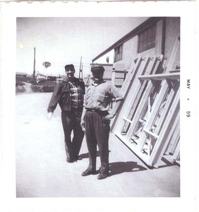 Young George and other man in front of warehouse.