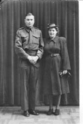 Full-length photo of man and woman standing in front of curtain, woman holding pair of gloves.