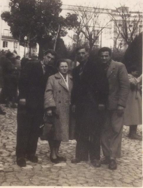 A woman and three men stand together and pose for the camera.