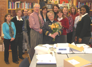 Marianne with bouquet of flowers, surrounded by staff of Pier 21.