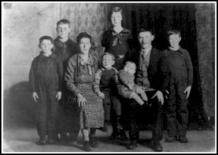 Black and white family portrait of mother, father and six children.