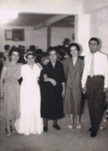 Four family members standing and a woman in a wedding dress.