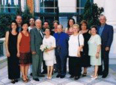 Recent colour photograph of several family members standing outside a building.