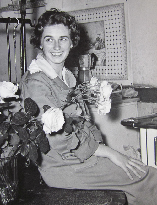 A woman seated holding flowers.