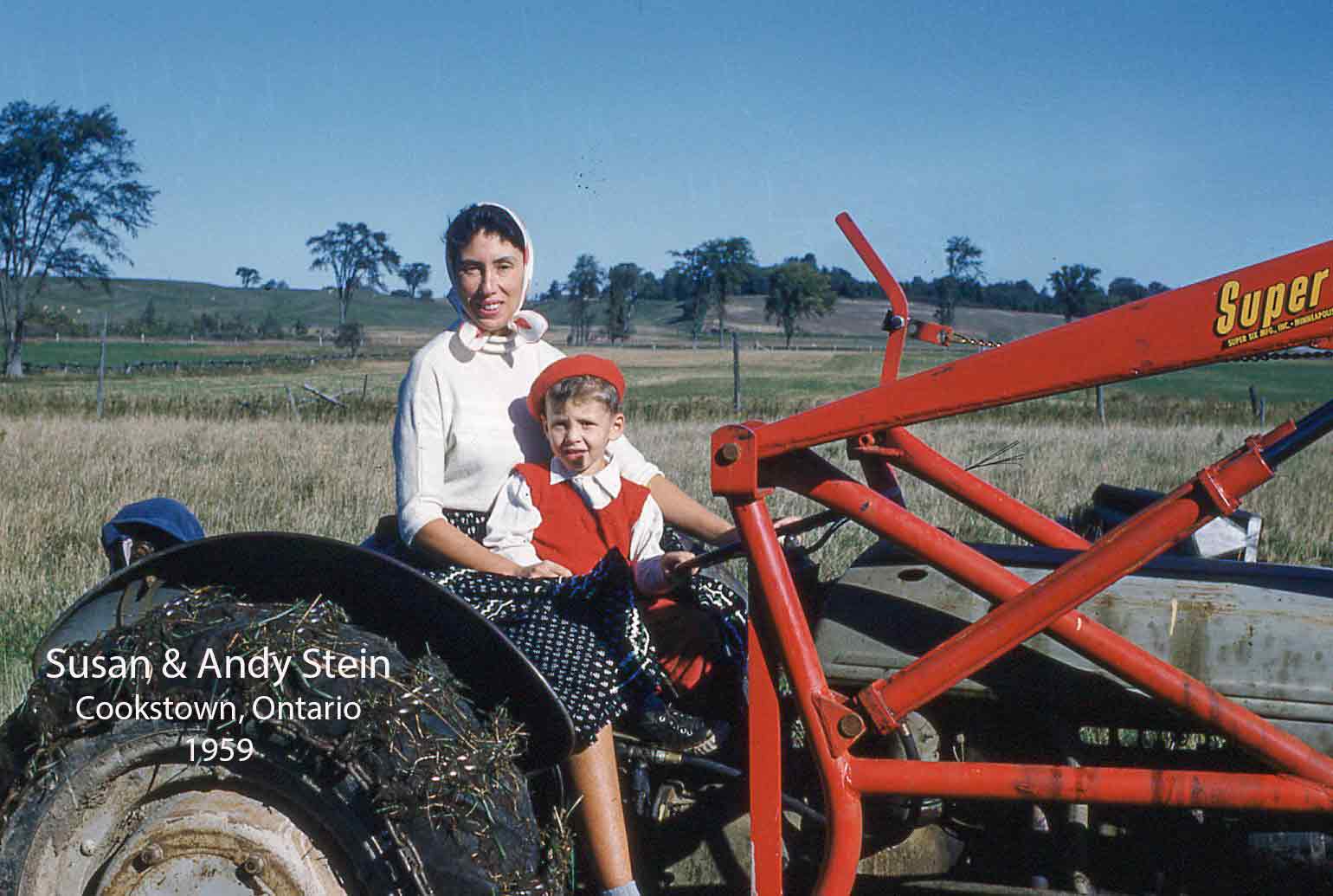 A Slovakian mother and child sit on a red tractor, smiling at the camera.