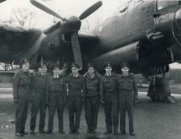 Seven young men dressed in uniform standing on tarmac in front of war plane.