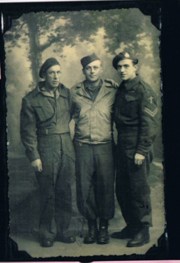 Three men in uniform standing in front of trees.