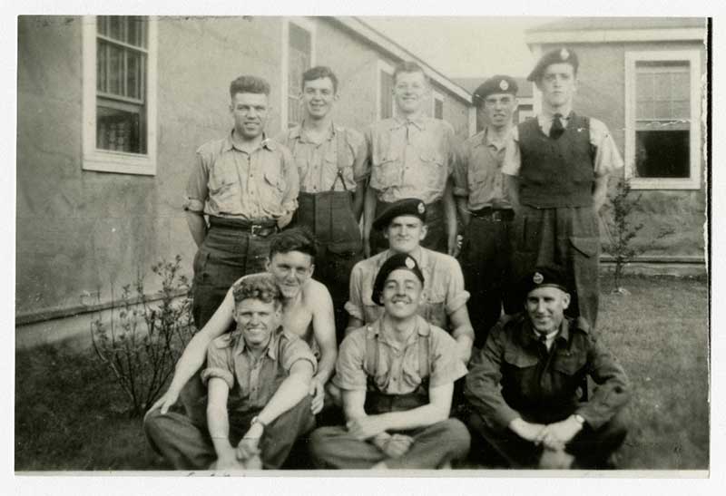 A group of young men sit and stand while posing for a photo.