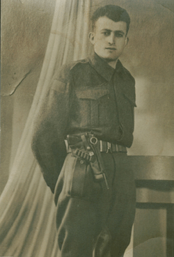 Full length portrait of Ernest as a young man, in military dress with gun belt.