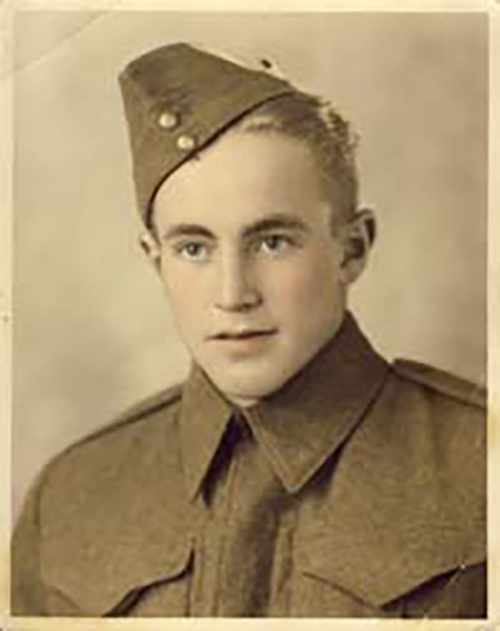 A young man in military uniform poses for a portrait.