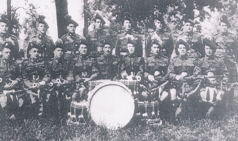 Several members of a military marching band pose for a photograph.