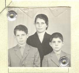 Family photograph for passport, woman in black a boy on each side. 