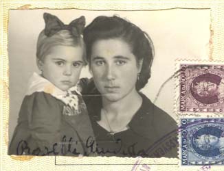 Family passport photo with woman in black holding baby with bow on head.
