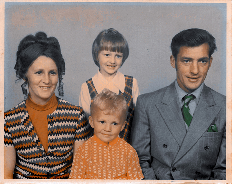 A family portrait of mother and father and two children in between, their clothing is reminiscent of the 1970's.