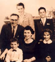 Old family portrait, mother sitting, father and children around her. 