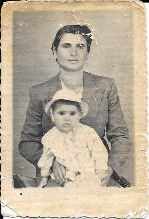 Old cracked photograph of a woman with a baby in her lap.