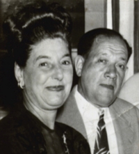 Woman and man pictured, smiling sideways at camera.