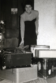 Sadie as a young woman surrounded by luggage trunks and suitcases.