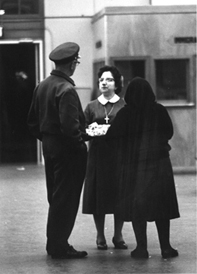 Sister Liota in a traditional nun’s outfit, talking to another woman and a man. 