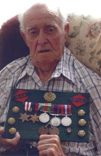 Older Clarence, holding medals, pins, shoulder badges, etc. dating from his war years.