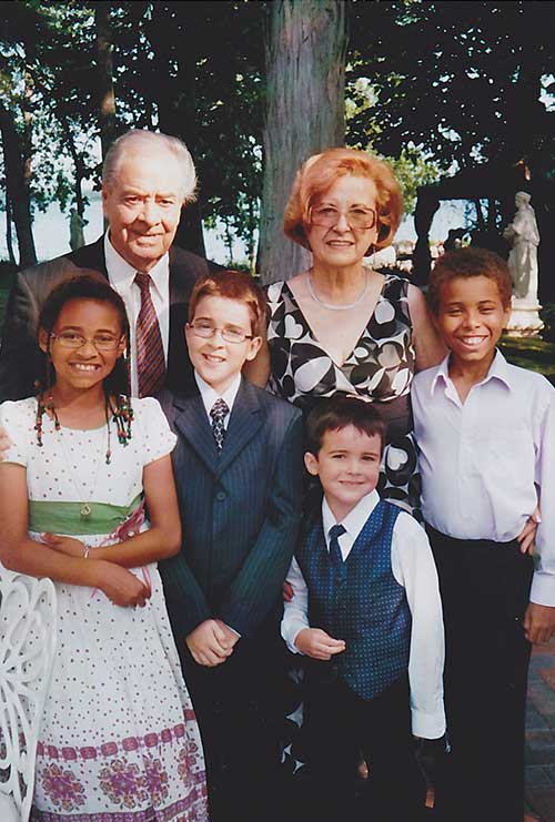 Grandparents standing with four grandchildren.
