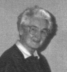 Black and white photo of older Gladys, wearing glasses.
