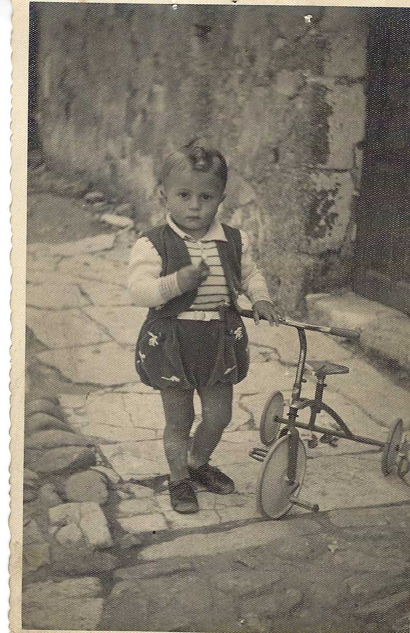 Black and white image of little boy in clothing of the era.