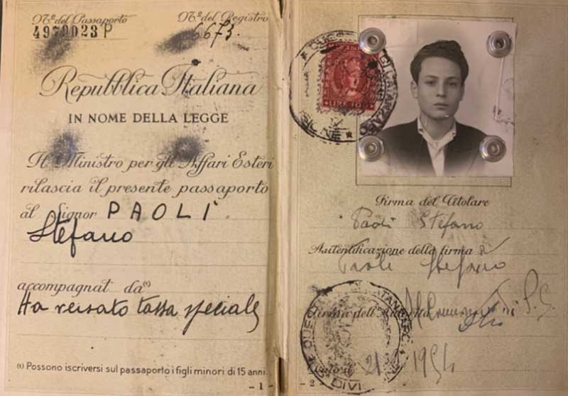 An old passport with a photo of a young man and immigration stamps.